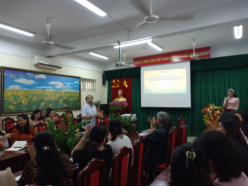 A group of people sitting in a room with a projection screenDescription automatically generated with low confidence