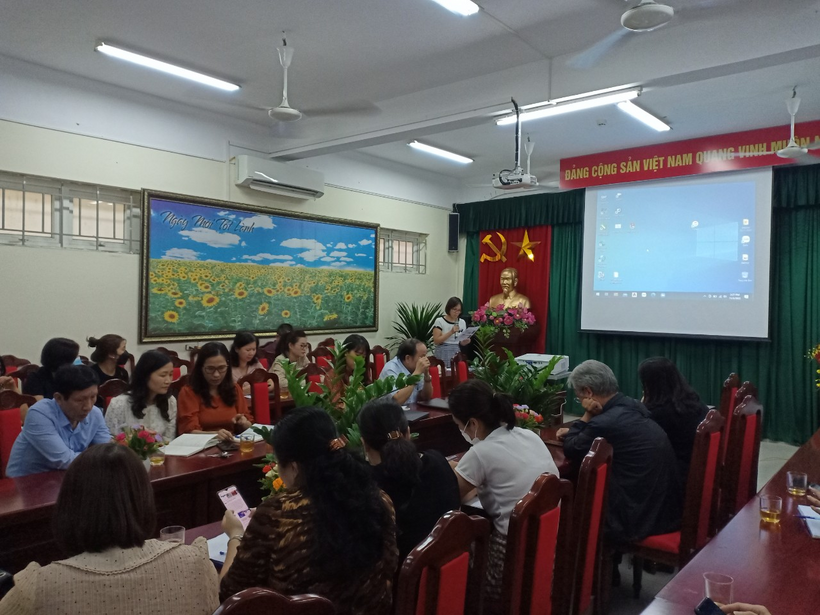 A group of people sitting in a room with a projection screenDescription automatically generated with low confidence