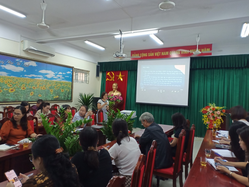 A group of people sitting in a room with a projection screenDescription automatically generated with low confidence