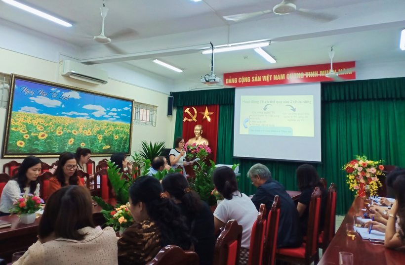 A group of people sitting in a room with a projection screenDescription automatically generated with low confidence