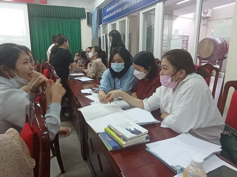A group of people sitting at desks with masks onDescription automatically generated with low confidence