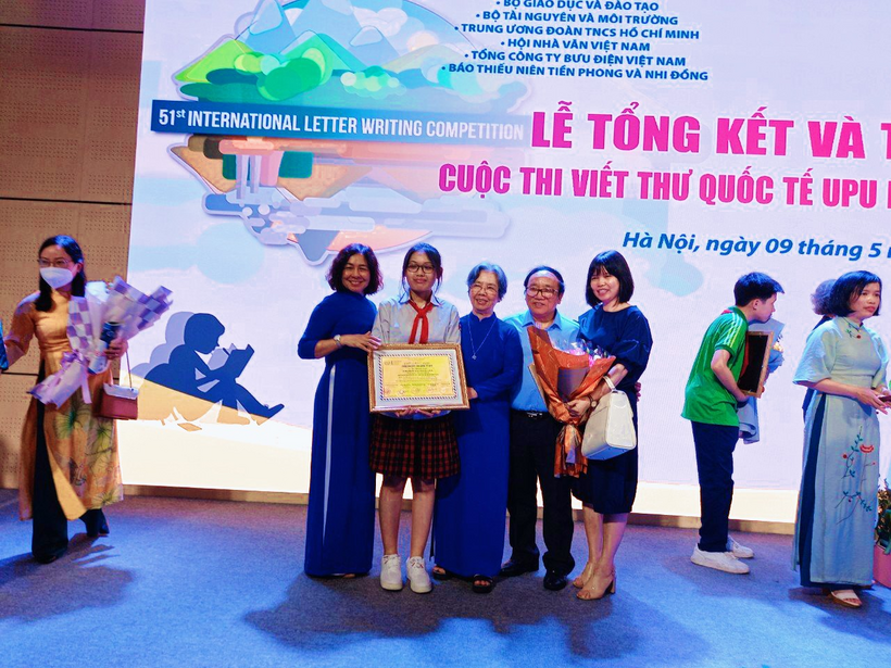 A group of people holding a plaqueDescription automatically generated with low confidence