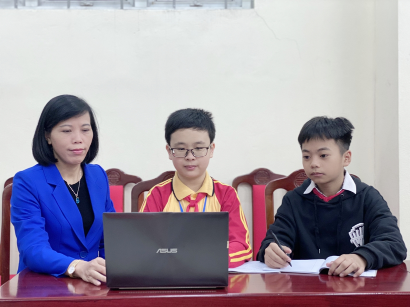 A group of people sitting at a table with a computerDescription automatically generated with medium confidence