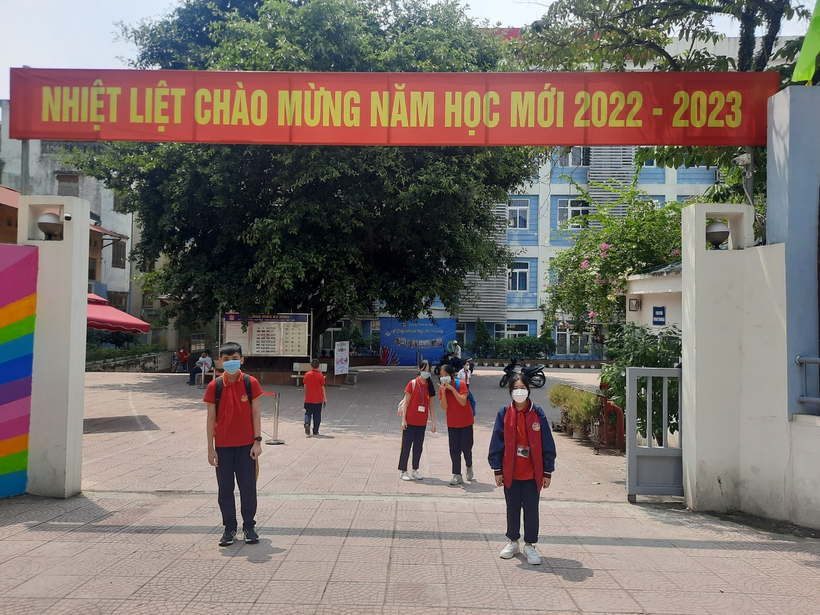 A group of people walking under a signDescription automatically generated with low confidence
