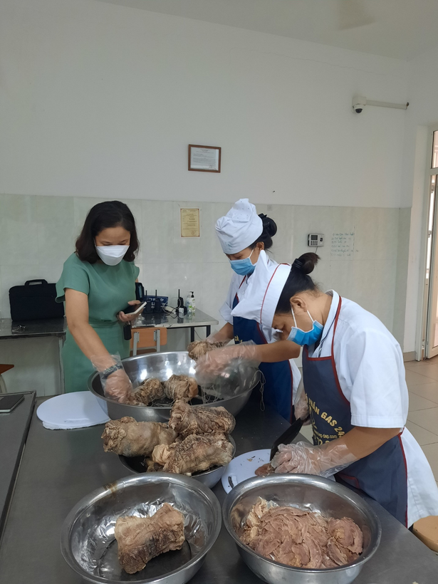 A group of people cooking in a kitchenDescription automatically generated with medium confidence