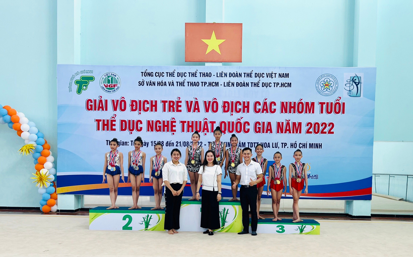 A group of people posing for a photo in front of a bannerDescription automatically generated