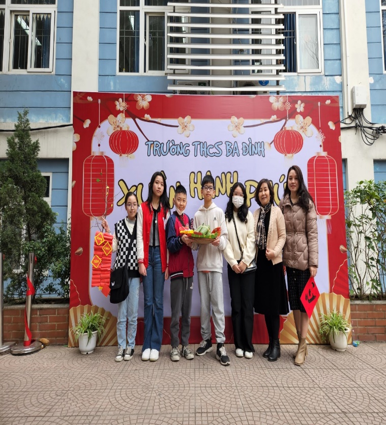 A group of women posing for a photo in front of a bannerDescription automatically generated with medium confidence