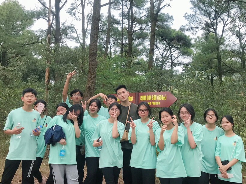 A group of people posing for a photo in front of a signDescription automatically generated