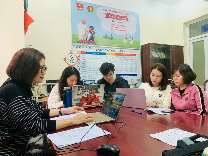 A group of people sitting at a table with laptopsDescription automatically generated with medium confidence