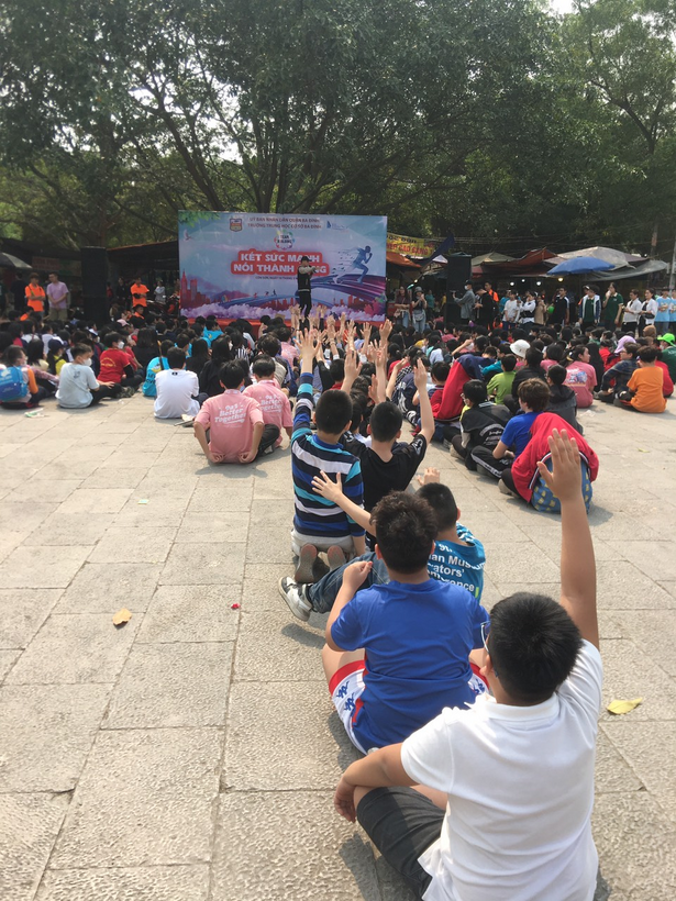 A group of people sitting on the groundDescription automatically generated with low confidence