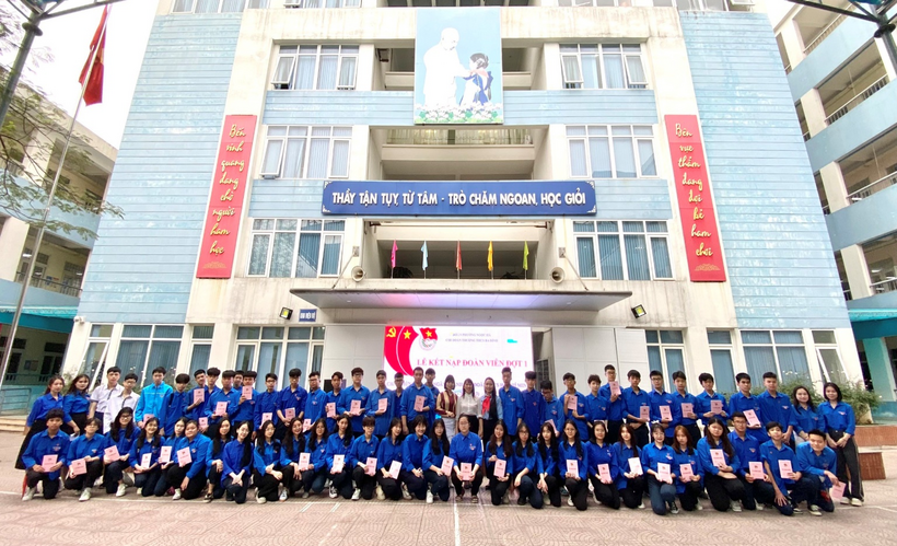 A group of people posing for a photo in front of a buildingDescription automatically generated