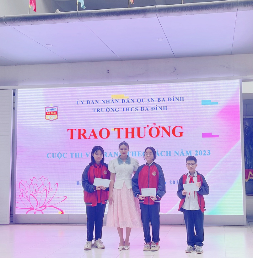 A group of people posing for a photo in front of a signDescription automatically generated with medium confidence