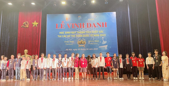 A group of people standing on a stage in front of a screenDescription automatically generated with medium confidence