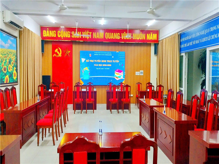 A room with red chairs and tablesDescription automatically generated