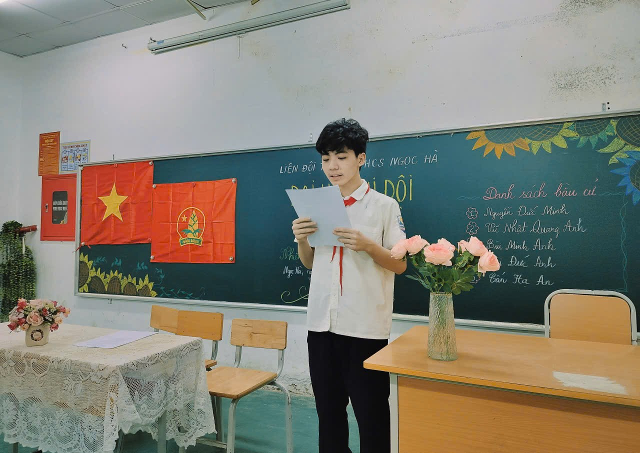 A child standing in a classroom reading a paper

Description automatically generated